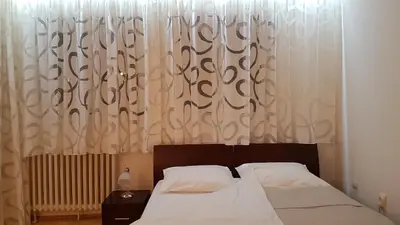 a bedroom with a bed and a window with curtains at Apartment Jasna in Belgrade