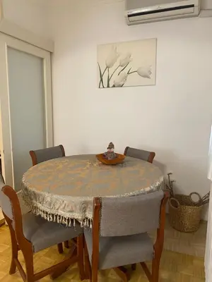 a dining room with a table and chairs and a painting at Apartment Jasna in Belgrade