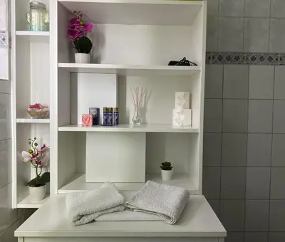 a white shelf with pillows and plants in a bathroom at Apartment Jasna in Belgrade