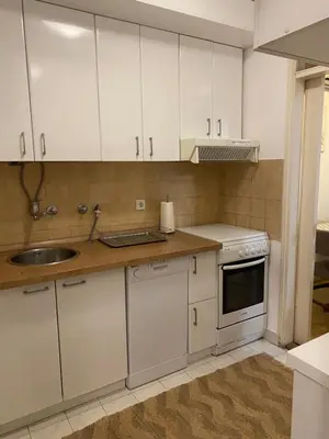 a kitchen with white cabinets and a sink at Apartment Jasna in Belgrade