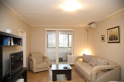 a living room with a couch and chairs and a tv at Havana Beograd Apartment in Belgrade