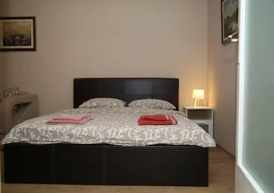 a bedroom with a large bed with two red pillows at Havana Beograd Apartment in Belgrade