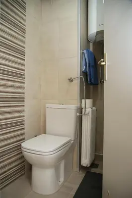 a bathroom with a white toilet in a room at Havana Beograd Apartment in Belgrade