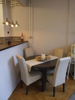 a dining room table with chairs and a candle on it at Arena Apartman in Belgrade