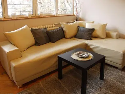 a couch in a living room with a table at Arena Apartman in Belgrade