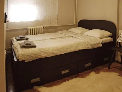 a bed in a bedroom with a window at Arena Apartman in Belgrade
