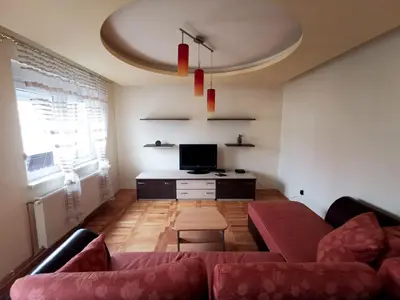 a living room with a couch and a tv at Apartman White in Belgrade