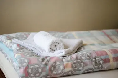a pile of towels sitting on top of a bed at Apartman White in Belgrade