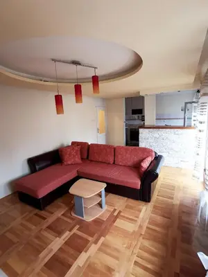 a living room with a red couch and a table at Apartman White in Belgrade