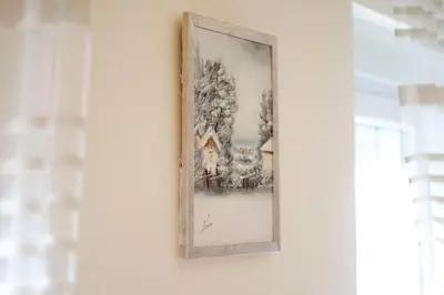 a framed painting hangs on a wall in a room at Apartman White in Belgrade