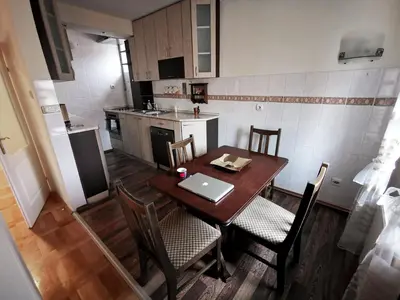 a kitchen with a wooden table with a laptop on it at Apartman White in Belgrade