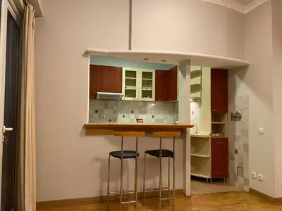 a kitchen with a bar with stools in it at Knez Mihailova, Beograd in Belgrade