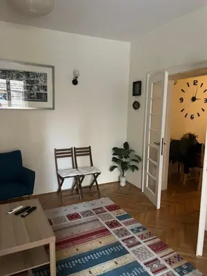 a living room with a table and a clock on the wall at Apartment No1 in Belgrade