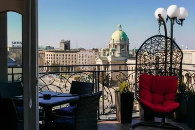 a balcony with a table and chairs and a building at President Lux in Belgrade