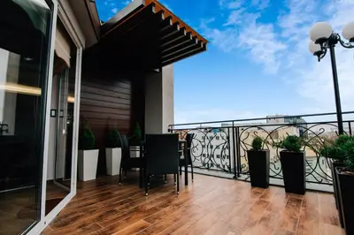 a balcony with a table and chairs on a balcony at President Lux in Belgrade