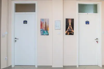a row of white doors with pictures on them at SAN 011 in Belgrade