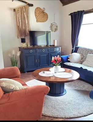 a living room with a blue couch and a table at Apartman Romy in Pančevo