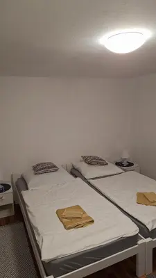 two beds in a room with white walls at Apartman Romy in Pančevo