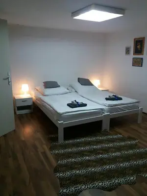 a bedroom with a white bed and a rug at Apartman Romy in Pančevo