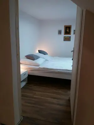 a bedroom with a large bed with white sheets and pillows at Apartman Romy in Pančevo