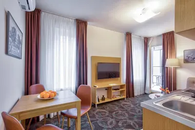 a hotel room with a kitchen and a living room at Booking Apartments in Belgrade