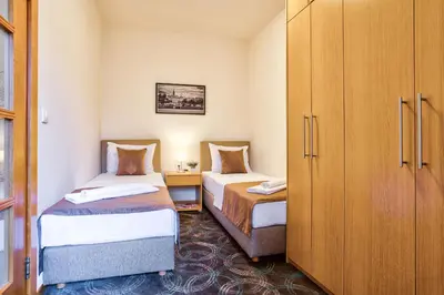 a small room with two beds and a cabinet at Booking Apartments in Belgrade