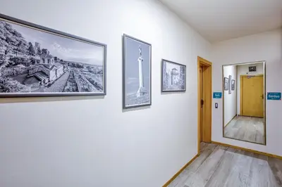 a hallway with three pictures on the wall at Booking Apartments in Belgrade