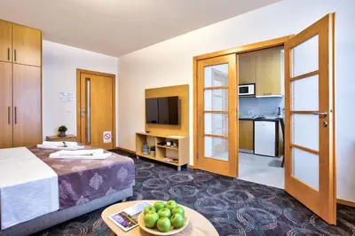a hotel room with a bed and a table with a bowl of fruit at Booking Apartments in Belgrade