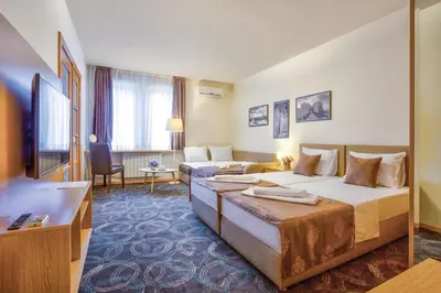 a hotel room with two beds and a television at Booking Apartments in Belgrade