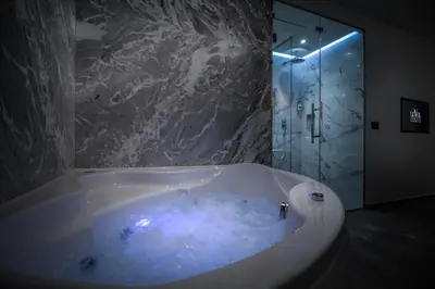 a bathroom with a large tub with a shower at Level Luxury Suites in Belgrade