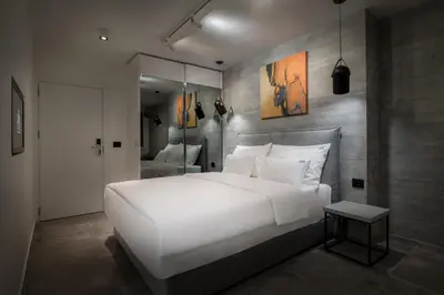 a bedroom with a large white bed and a mirror at Level Luxury Suites in Belgrade