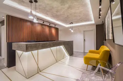 a lobby with a yellow chair and a counter at Level Luxury Suites in Belgrade