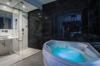 a bathroom with a blue tub and a shower at Level Luxury Suites in Belgrade