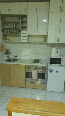 a kitchen with white cabinets and a stove and a sink at Vracar Krunska Jamiva in Belgrade
