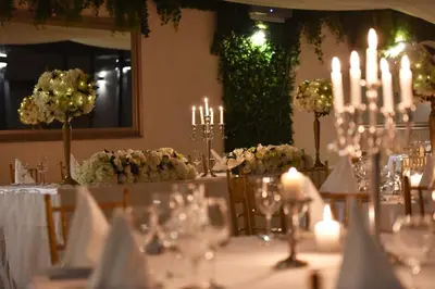 a table with candles and flowers in a room at The Belgrade Hills Rooms and Suites in Belgrade