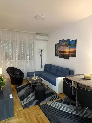 a living room with a blue couch and a table at Barbara in Belgrade
