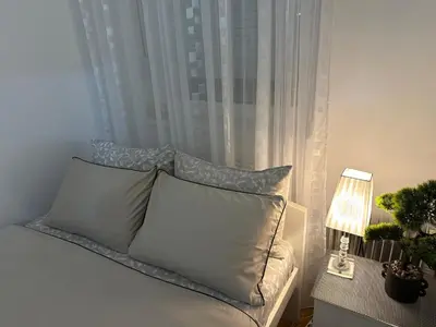 a bed with pillows and a lamp on a table at Barbara in Belgrade