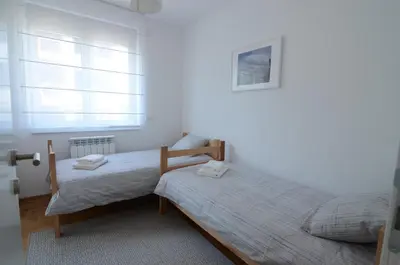 a bedroom with two twin beds and a window at Apartman Nodilova in Belgrade