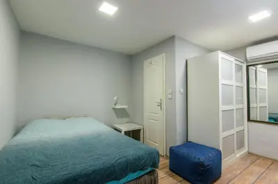 a small bedroom with a bed and a mirror at House of Vracar in Belgrade