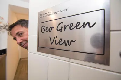 a man standing in a bathroom with a sign that reads big green view at Beo Green View in Belgrade