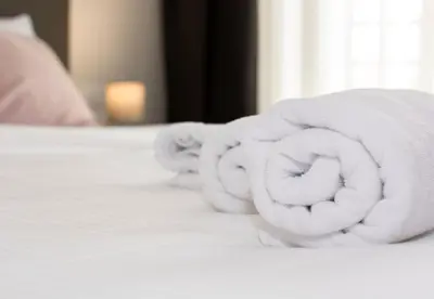 a pile of white towels on a bed at Beo Green View in Belgrade