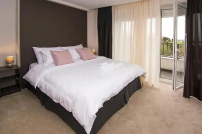 a bedroom with a large bed with pink pillows at Beo Green View in Belgrade
