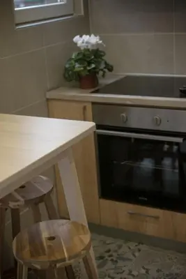a kitchen with an oven and a table and stools at Free.three in Belgrade