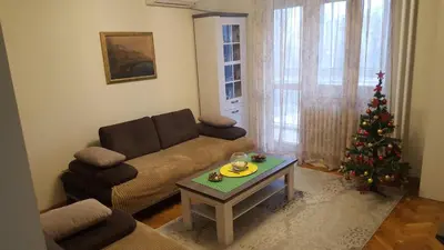 a living room with a christmas tree and a couch at Apartman Jogi in Vračar (historical)