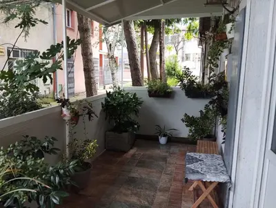 a porch with potted plants and a bench on it at Apartman Fenix in Belgrade
