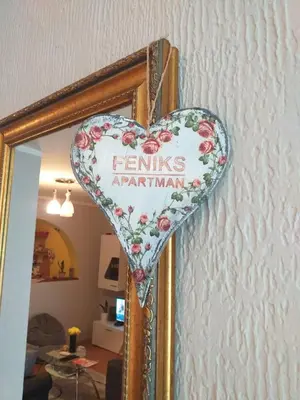 a mirror with a heart shaped sign on a wall at Apartman Fenix in Belgrade
