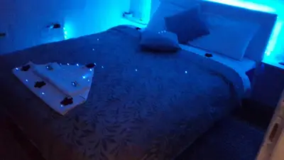 a room with a bed with a blue light at Apartman Fenix in Belgrade
