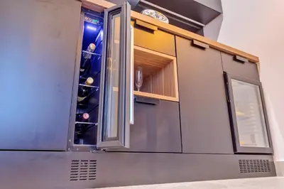 a kitchen with a cabinet with wine bottles in it at Black Pearl Luxury Suites in Belgrade