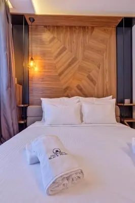 a white bed with a towel on top of it at Black Pearl Luxury Suites in Belgrade