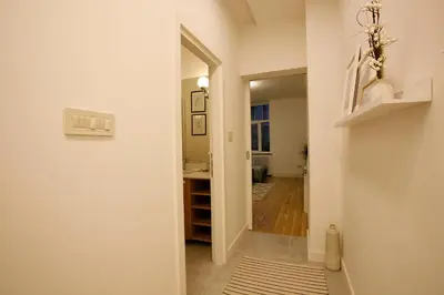 a hallway with a door leading to a bathroom with a sink at BestStay Apartment No 9 Pedestrian zone in Belgrade